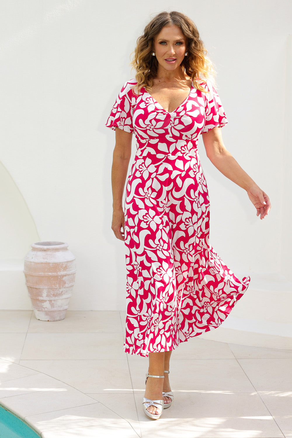 Woman stands poolside in Mica Maxi Dress from Leina & Fleur's Cherry charm collection. This maxi dress is perfect for event dressing this summer season. Made from dry touch jersey fabric to ensure you stay cool and comfortable while maintaining a polished appearance. Shop Mica Maxi Dress in sizes 8-24.