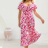Woman stands poolside in Mica Maxi Dress from Leina & Fleur's Cherry charm collection. This maxi dress is perfect for event dressing this summer season. Made from dry touch jersey fabric to ensure you stay cool and comfortable while maintaining a polished appearance. Shop Mica Maxi Dress in sizes 8-24.