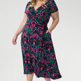 The fully functioning wrap style includes extended waist ties for a customisable fit, while the double-layer back bodice offers added comfort and structure. Thoughtful details like gathered sleeve heads, an A-line skirt, and practical side pockets enhance both style and functionality.