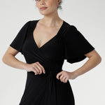 Glamorous Alita Black Wrap Dress with sheen finish, deep hem ruffle, and flattering wrap silhouette for special occasions.