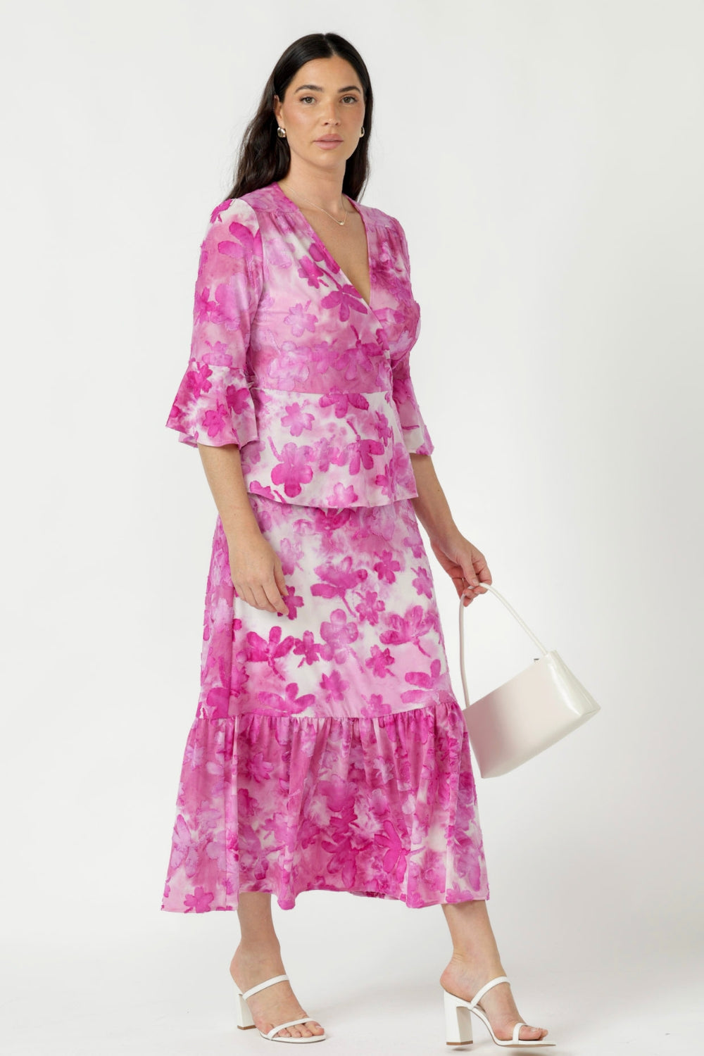 Amora wrap-style top in textured burnout fabric featuring gathered shoulders, statement fluted sleeves and a feminine peplum hem for effortless movement