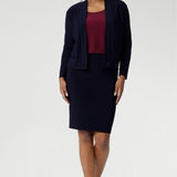 The Andi Tube Skirt is available in a mini, regular and midi length for a bold and stylish look no matter your style. Size 10 woman wears her navy tube skirt with matching jacardi in navy & ruby Top.
