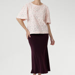 Featuring delicate ivory embroidery on a soft powdered pink base, it’s designed in a relaxed silhouette with a round neckline, topstitch detailing, and flared short sleeves finished with a subtle pleat.