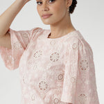 Australian designed top in a relaxed silhouette with a round neckline, topstitch detailing, and flared short sleeves finished with a subtle pleat.