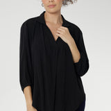 Over 30's woman wears a woven shirt with collar and tailored pleat front. Made from sustainable tencel fabric. Made in Australia for women size 8-24. 