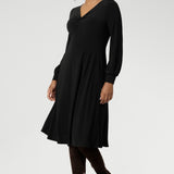 The Bianca Dress is a versatile wardrobe essential, designed to take you from work to events with effortless elegance. This classic black knee-length dress features a flattering V-neckline and a twist-front bodice that enhances your shape, while the cuffed long sleeves add a polished finish.