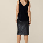 Back view of a sparkly skirt for evening and event wear. This pencil skirt shape glitters in navy blue shimmer jersey. Sitting below the knee, this is the good length for cocktail dress codes. Made in Australia in sizes 8 to 24.