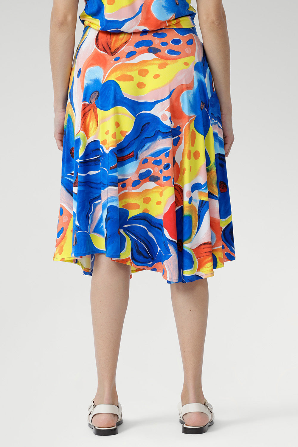 The Casey Dress in Summer Bliss captures effortless sophistication. Crafted from our slinky jersey with a smooth, cooling touch and gentle stretch, it features a graceful cowl neckline, blouson bodice, and asymmetrical hem. Shoulder-tucked sleeves and a statement floral print complete this lightweight piece. Ideal for holidays, relaxed weekends, and balmy summer afternoons. Australian made in sizes 8–24.