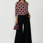 Collins Top with boat neckline and 3/4 sleeves in a bold Ruby Connection geometric print, crafted from premium dry-touch jersey with a flattering fitted silhouette.