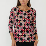 Collins Top in Ruby Connection geometric print featuring a black base with red, gold and vanilla tones, crafted from soft stretch dry-touch jersey with a chic boat neckline and 3/4 sleeves.