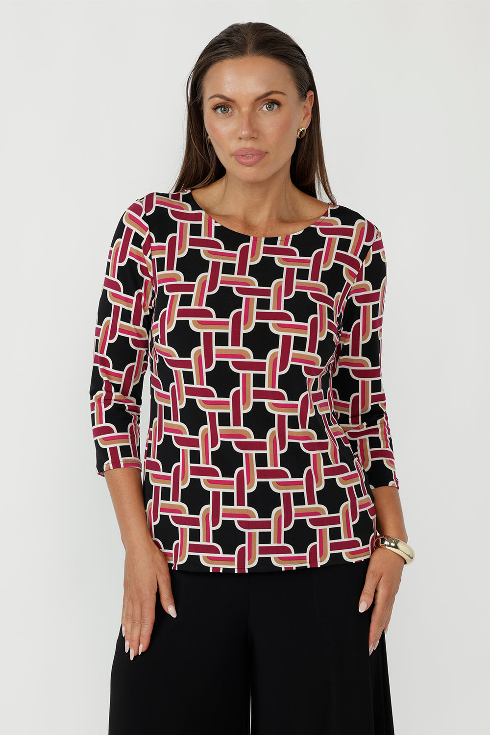 Collins Top in Ruby Connection geometric print featuring a black base with red, gold and vanilla tones, crafted from soft stretch dry-touch jersey with a chic boat neckline and 3/4 sleeves.