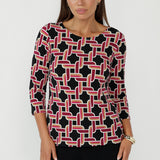 Collins Top in Ruby Connection geometric print featuring a black base with red, gold and vanilla tones, crafted from soft stretch dry-touch jersey with a chic boat neckline and 3/4 sleeves.