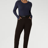 Designed for comfort and versatility, it features a flattering close-to-body fit that moves with you, thanks to its generous stretch and breathable finish. Size 10 woman wears her wool top tucked into her cocoa coloured tapered leg pants. 