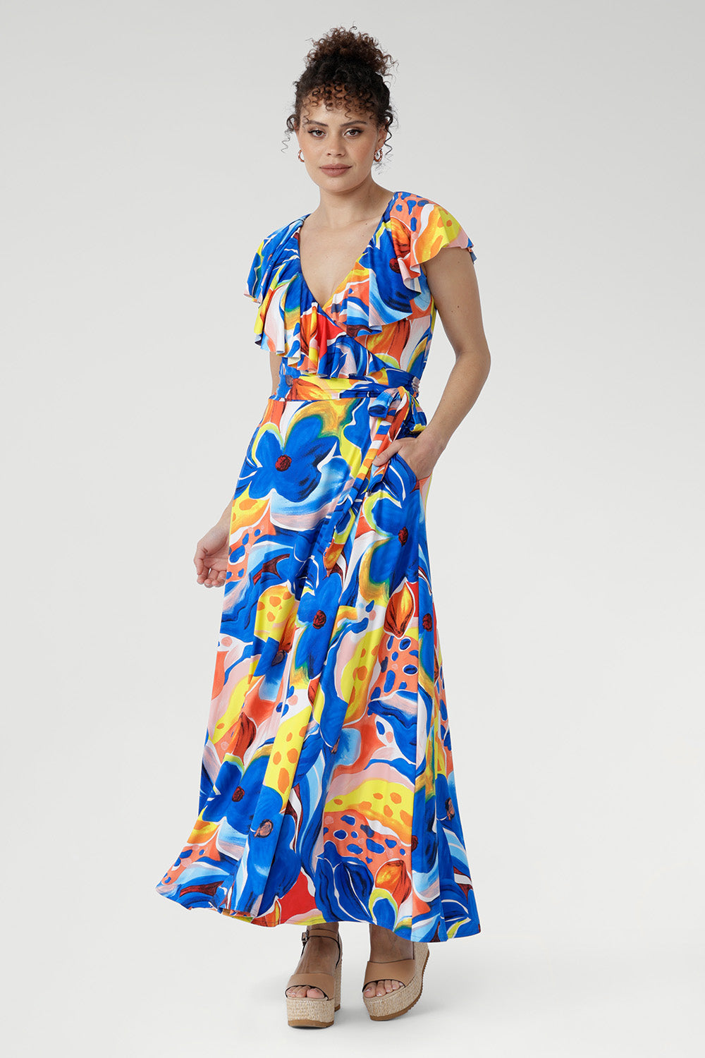 Crafted from our cool-touch slinky jersey, the Elle Maxi Wrap Dress in Summer Bliss combines effortless elegance with modern detail. The wrap silhouette and tie waist create a flattering shape, complemented by a laser-cut raw edge frill for a touch of lightness. With pockets and a double-layered back for comfort, this abstract floral dress is made for summer festivals, garden parties, and relaxed occasions.