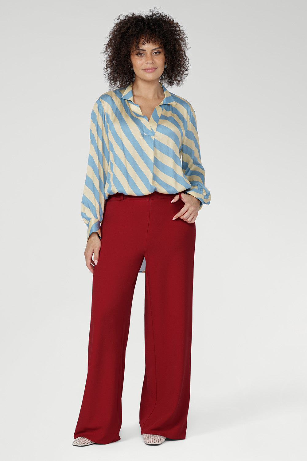 Long full-length sleeves with covered button cuffs and a flattering shirt-tail hemline — longer at the back — add versatility and ease to this pull-on style. Tuck detailing below the back neckline further elevates the design.