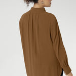 Plus size woman wears lightweight, easy to wear shirt that holds its shape without stretch. In the warm neutral shade of Nuthatch, it brings subtle sophistication to everyday dressing.
Available in size 8-24.