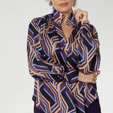 A structured collar frames the neckline, leading into a soft V-neckline with a tailored tuck at the centre, adding subtle shaping to the relaxed design. Thoughtful tuck details at the back enhance the swing silhouette, offering both style and structure. 