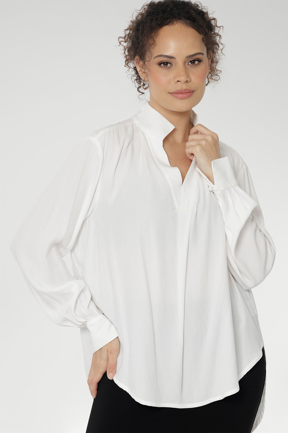 A size 10 woman wears the Ellis shirt in Vanilla tencel, a high quality made in Australia womens shirt made in breathable tencel. Inclusive size range 8-24 and made in Australia. Styled back with Black Tube Skirt 