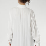 Back view of a size 10 woman wears the Ellis shirt in Vanilla tencel, a high quality made in Australia womens shirt made in breathable tencel. Inclusive size range 8-24 and made in Australia. Styled back with the Deni pants in Black velour.