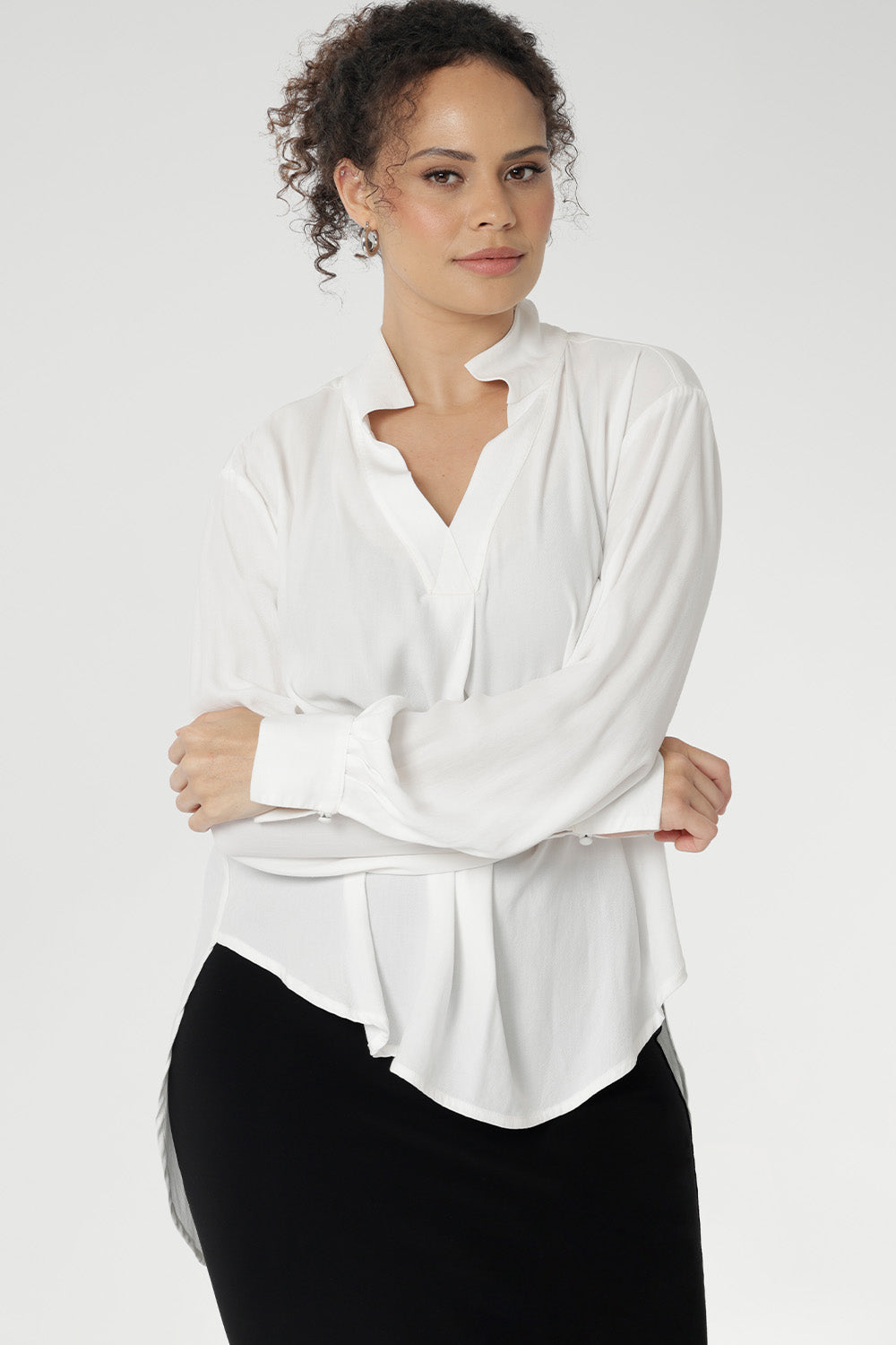 A size 10 woman wears the Ellis shirt in Vanilla tencel, a high quality made in Australia womens shirt made in breathable tencel. Inclusive size range 8-24 and made in Australia. Styled back with Black Tube Skirt 