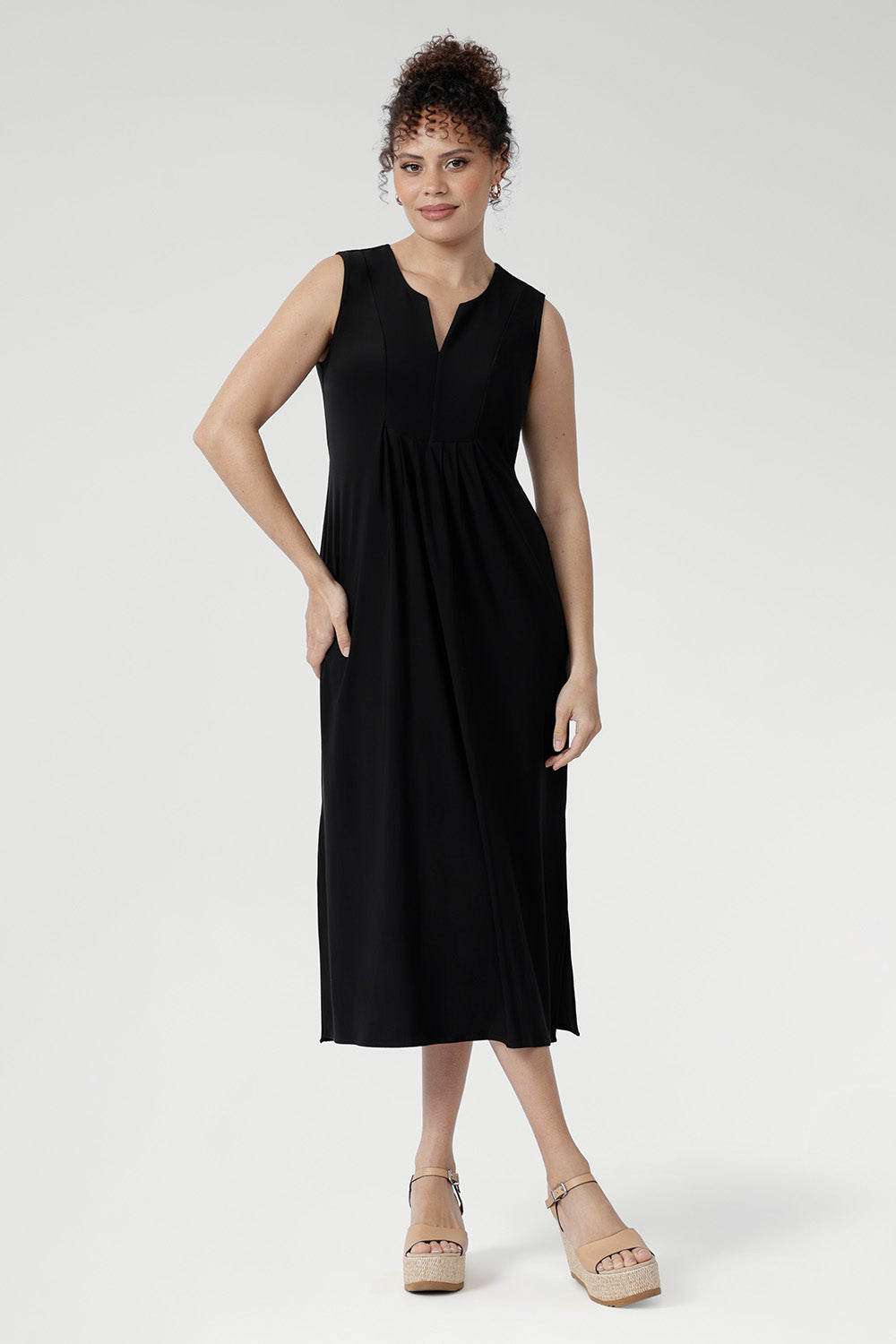Fernanda Dress in Black — sleeveless slinky midi sundress with front pleats and waist ties, perfect for summer getaways and resort wear.