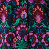 This vibrant printed fabric, featuring bold hues of pink, green, burgundy, and blue, is used to create a stunning collection of women’s spring fashion, including a maxi wrap dress, culotte pants, and a flutter sleeve top. Proudly made in Australia and available in sizes 8 to 24.