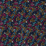 Close up swatch image of Harmony print, which features a navy dry-touch jersey base adorned with floral details in rich hues of magenta, mustard, blue, and vanilla. Used to create garments for a summer corporate wardrobe in sizes 8-24.