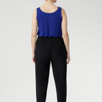 The Indi Pant combines comfort and style in a sleek, tapered silhouette. Made from lightweight black dry-touch jersey with stretch, it features a mid-rise pull-on fit, front gathers, and ankle cuffs with tuck detail. Easy to dress up with a blazer or wear casually for travel days. Available in two heights.