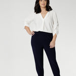 Petite height model wears  travel pant that feature dropped crotch & tapered legs. Model is size 10. Travel ready pants made from stretchy jersey for ultimate comfort. Made for Australian and New Zealand women, by clothing brand Leina & Fleur. Now available in sizes 8-24 and in 2 lengths.