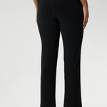 Size 10 model pairs black pants with white top & black loafers for a casual look.