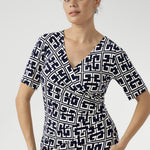 Designed for seamless transitions from the office to evening events and weekend outings, this versatile dress features a flattering fixed wrap bodice, a sophisticated knee-length tulip skirt, and above-elbow sleeves that strike the perfect balance between coverage and style.