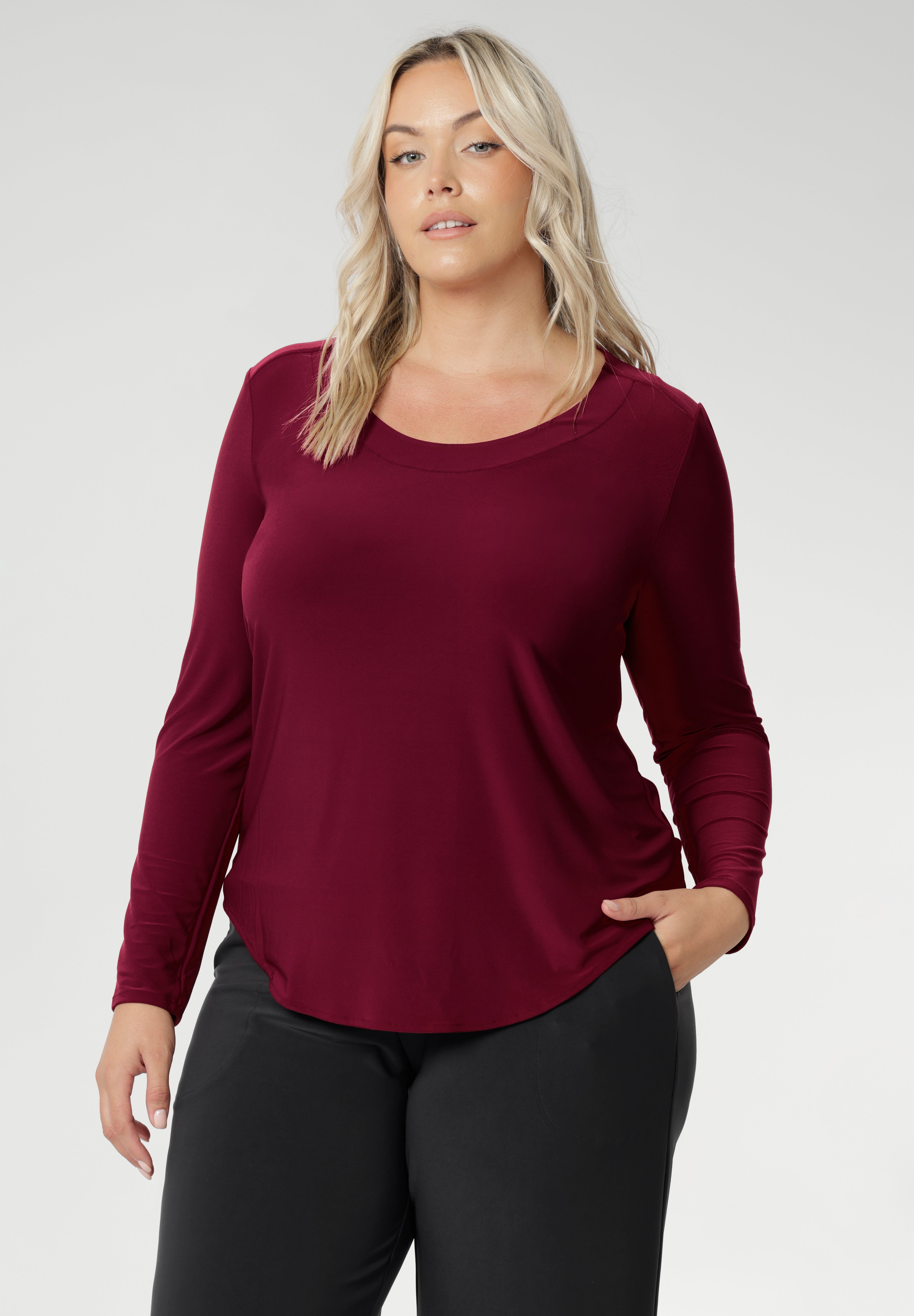 This flattering silhouette features subtle bust darts for shape, a clean round neckline with facing detail, and a refined back shoulder yoke with a centre-back pleat that adds gentle structure. Long fitted sleeves offer warmth without bulk, while the shirttail hemline creates a smooth finish that sits beautifully over the hips or can be easily tucked. Whether you’re layering up or wearing it on its own, the Leith Top in its rich Ruby hue brings both versatility and style to your everyday wardrobe.