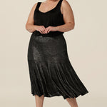 A size 18, plus size woman wears a midi length, foil print evening skirt with ruffle hem. For cocktail and evening wear, this elegant skirt is worn with a black cami top. Both going out skirt and top are made in Australia by women's fashion brand, Leina & Fleur. Shop their evening and cocktail wear online in sizes 8 to 24.
