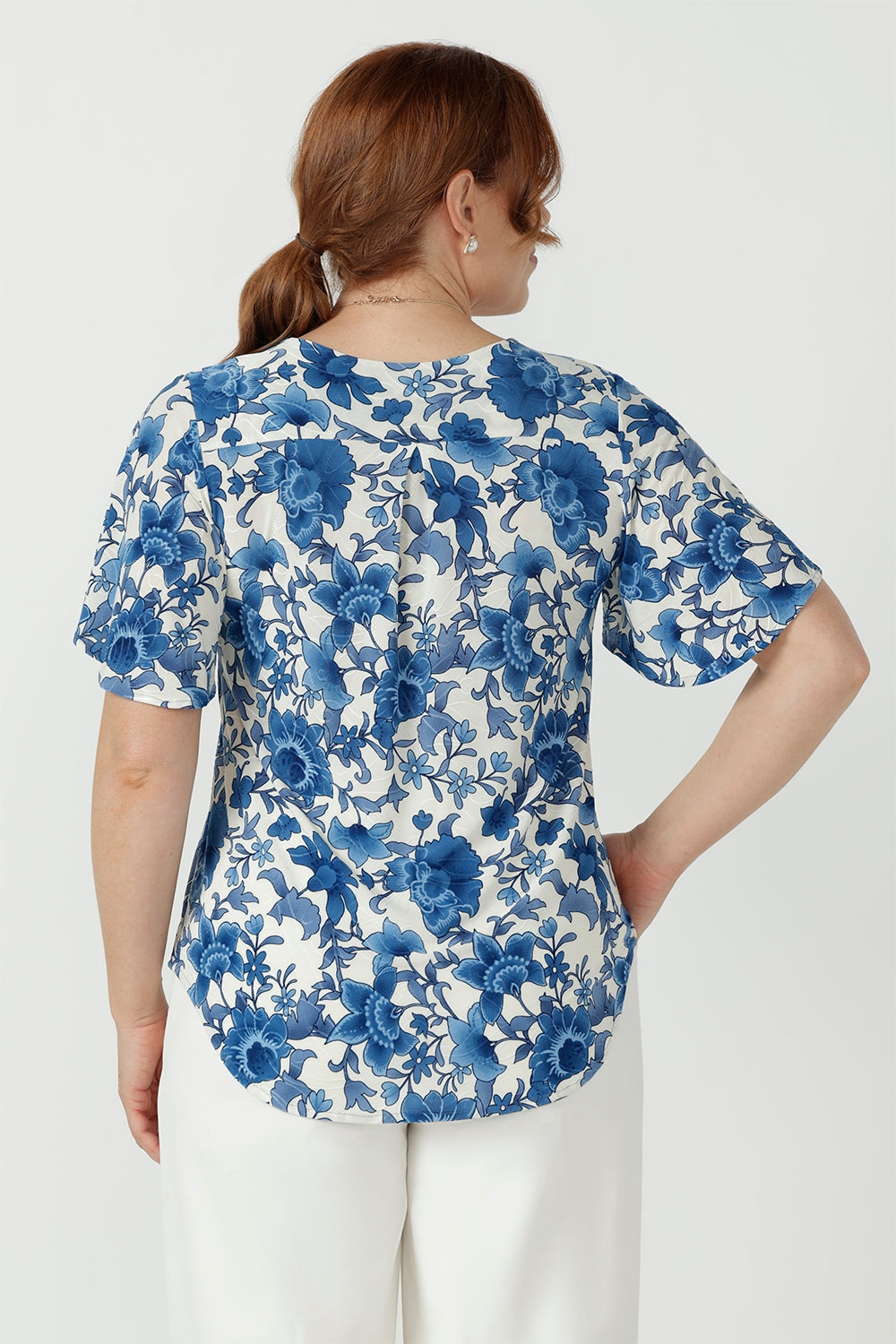 Lila women's top crafted from soft stretch embroidered jersey, featuring elegant flutter sleeves, bust darts and a gently curved shirttail hem.