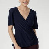 Crafted from luxe slinky fabric in a rich deep navy, the Lyle Top in Dark Navy features a flattering V-neck wrap front with a soft flounce detail. With short sleeves and a versatile silhouette, it layers effortlessly under jackets or stands alone as a polished summer essential.