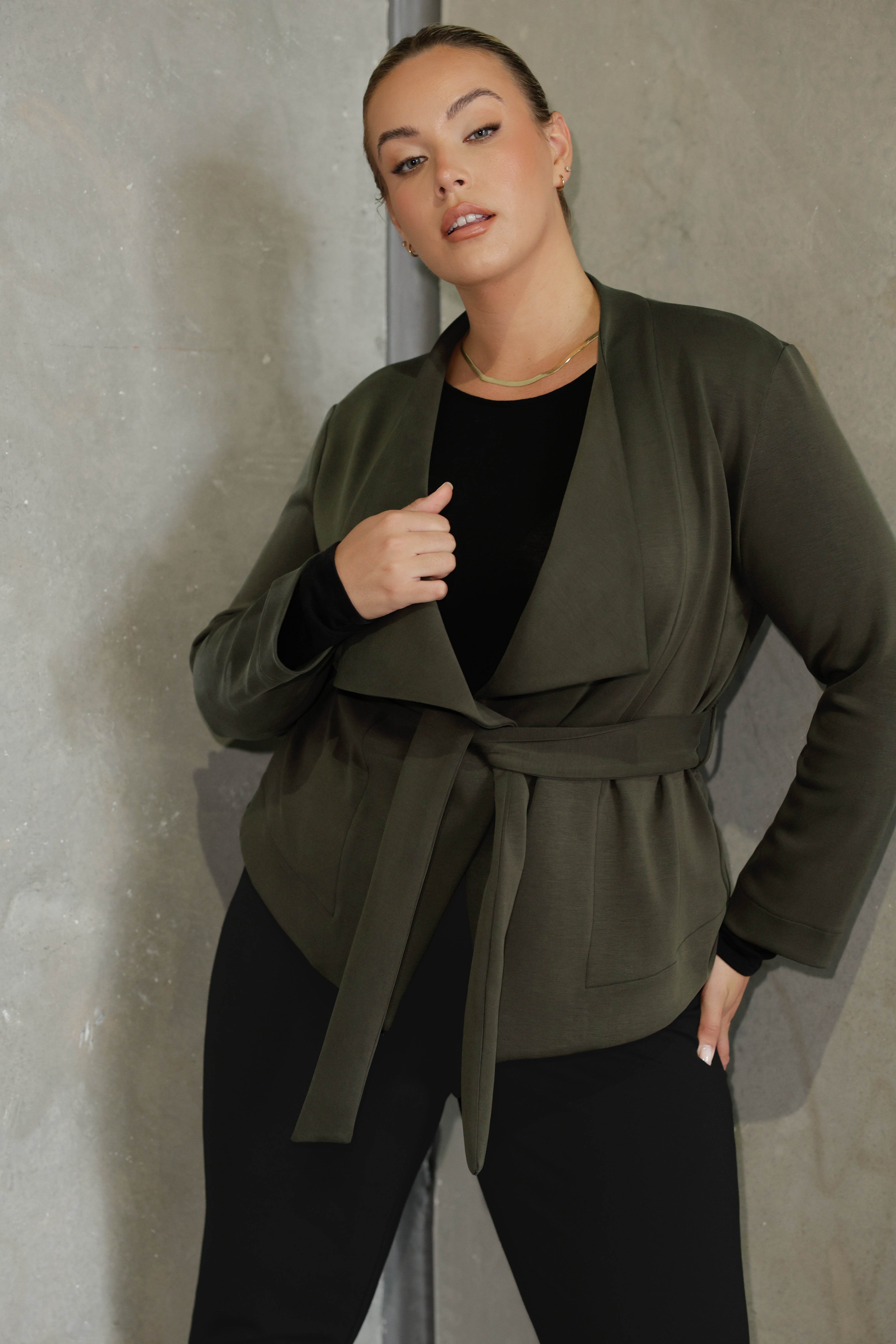 Lyndon features a double-layer jacket with   angled front panels for a modern edge and a detachable waist tie with belt loops, allowing you to wear it open or cinched to define your silhouette. 