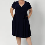 Workwear dress for the women on the go. Size 18 model wears navy coloured wrap dress. Made from high quality dry touch jersey. Australia made dresses in petite to plus sizes online at Australian Leina & Fleur in sizes 8-24.