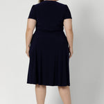Workwear staple for the women on the go. Plus size model wears navy coloured wrap dress. Made from heavy weight dry touch jersey. Shop made in Australia dresses in petite to plus sizes online at Australian Leina & Fleur in sizes 8-24.