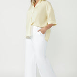 Luxe Martha Shirt featuring a relaxed oversized fit, natural textured fabrication and refined tailoring, proudly designed and made in Australia. Plus size women wears relaxed linen tee paired with white dress pants & heels