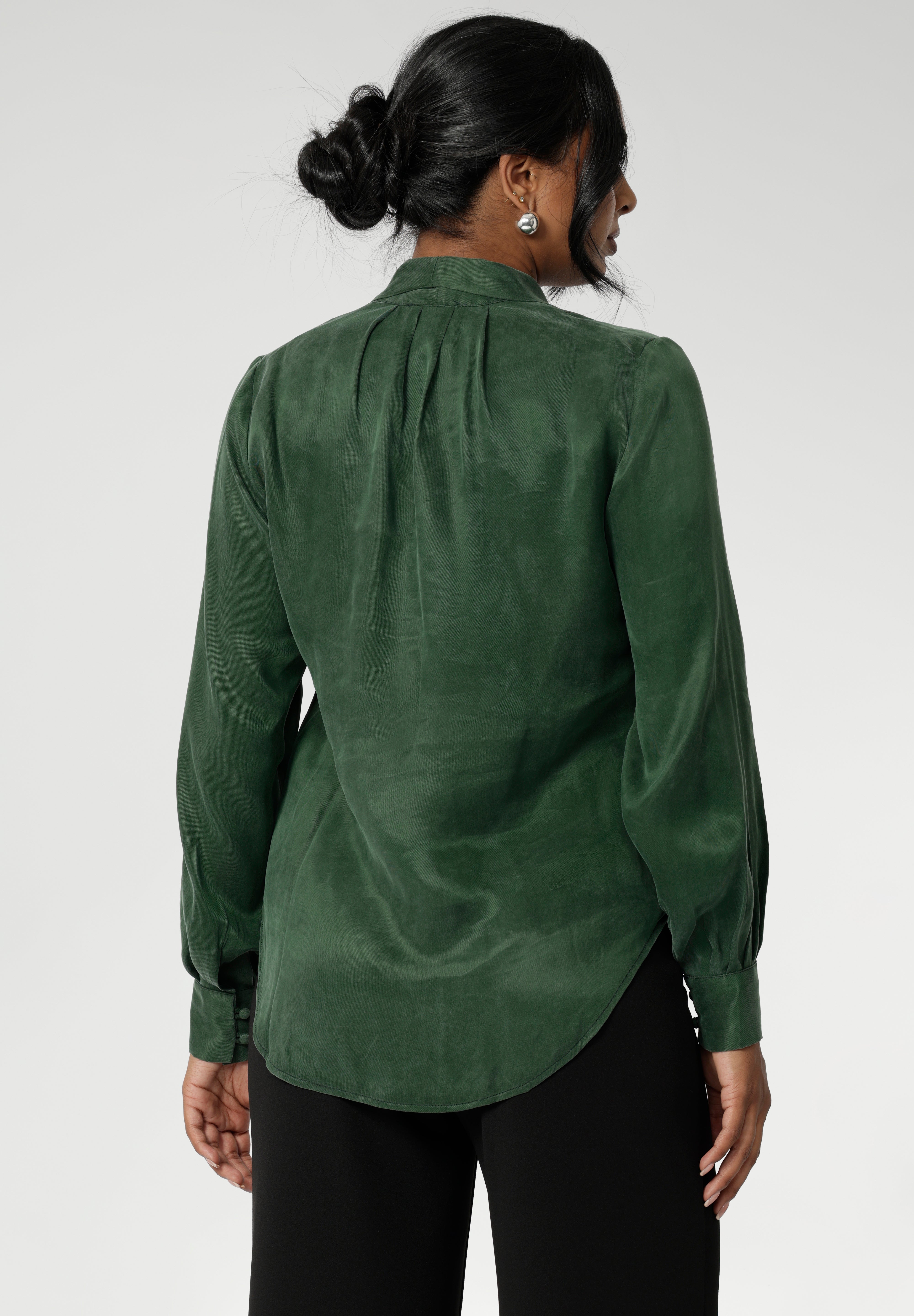 Crafted from suede touch Tencel that has a luxurious feel and drape. Proudly made in Australia in sizes 8-24. The Matisse Shirt in Deep Green is a pull-on style with a tie neckline, crafted from soft, fluid fabric. Blouson sleeves and buttoned cuffs add a polished finish. Matisse is a semi-fitted pull on style V-neckline shirt with extended neck ties, back pleats and bishop sleeves.