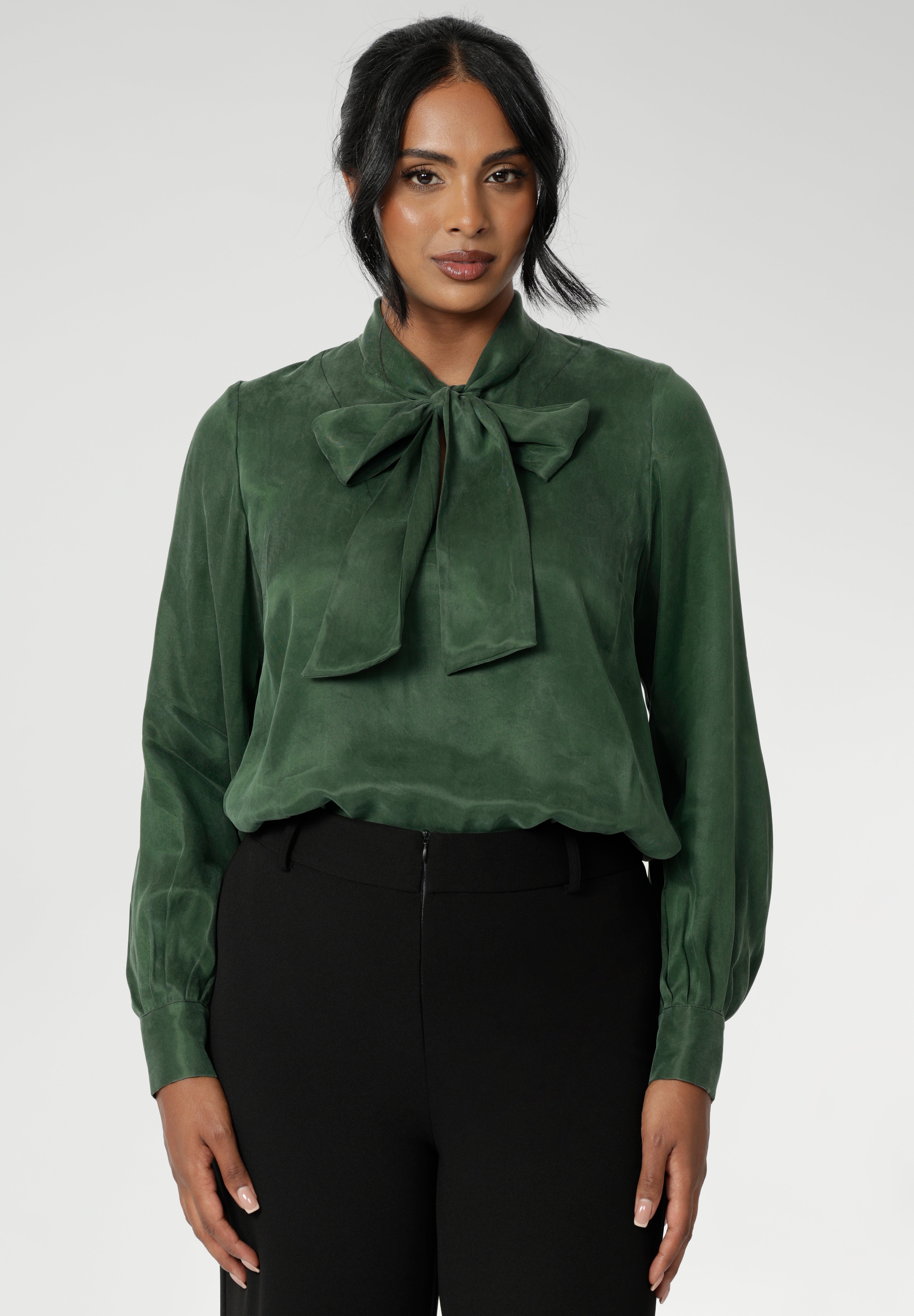 Crafted from suede touch Tencel that has a luxurious feel and drape. Proudly made in Australia in sizes 8-24. The Matisse Shirt in Deep Green is a pull-on style with a tie neckline, crafted from soft, fluid fabric. Blouson sleeves and buttoned cuffs add a polished finish. Matisse is a semi-fitted pull on style V-neckline shirt with extended neck ties, back pleats and bishop sleeves.