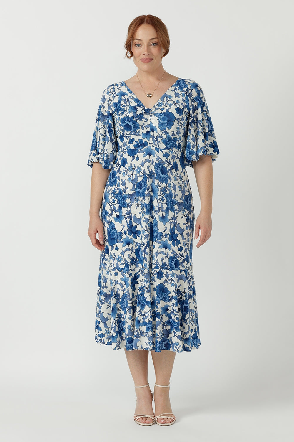 Elegant women's occasion dress crafted from cool-touch embroidered jersey, featuring a feminine twist-front bodice, flowing silhouette and statement sleeves.
