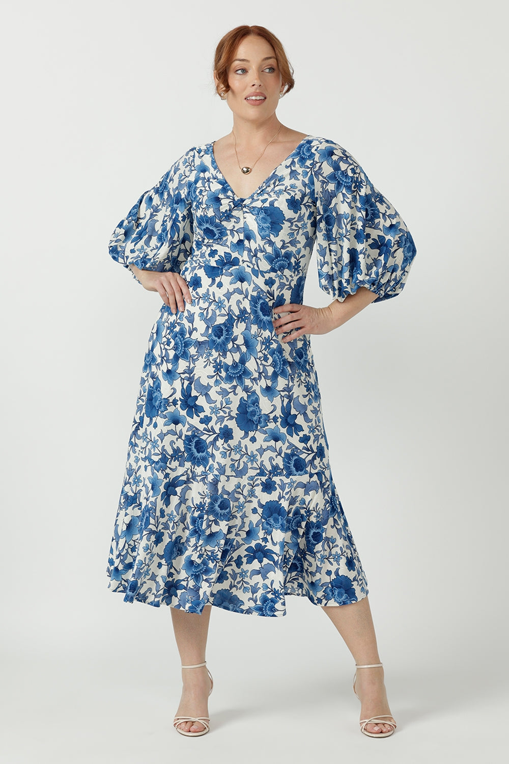 Elegant Melina Dress crafted from luxe embroidered jersey, featuring a flattering empire-line silhouette, twist-front bodice and flowing ruffle hem.