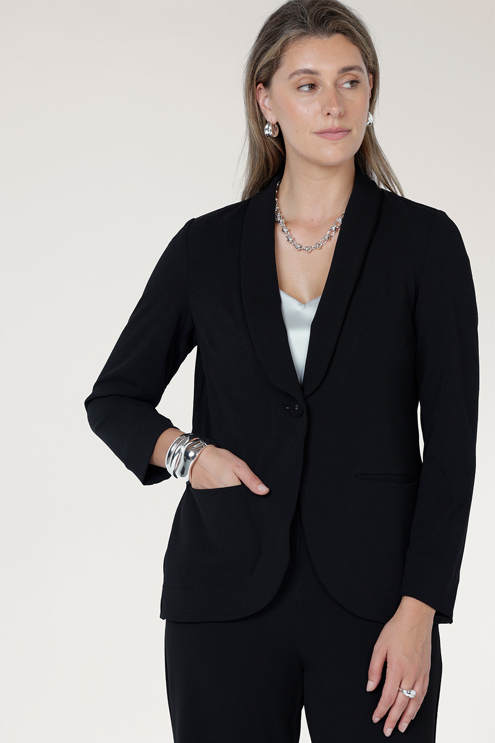 Perfect for work, Merit features a button front, full-length sleeves with foldable cuffs, and an extended shawl collar, offering versatile style and comfort.