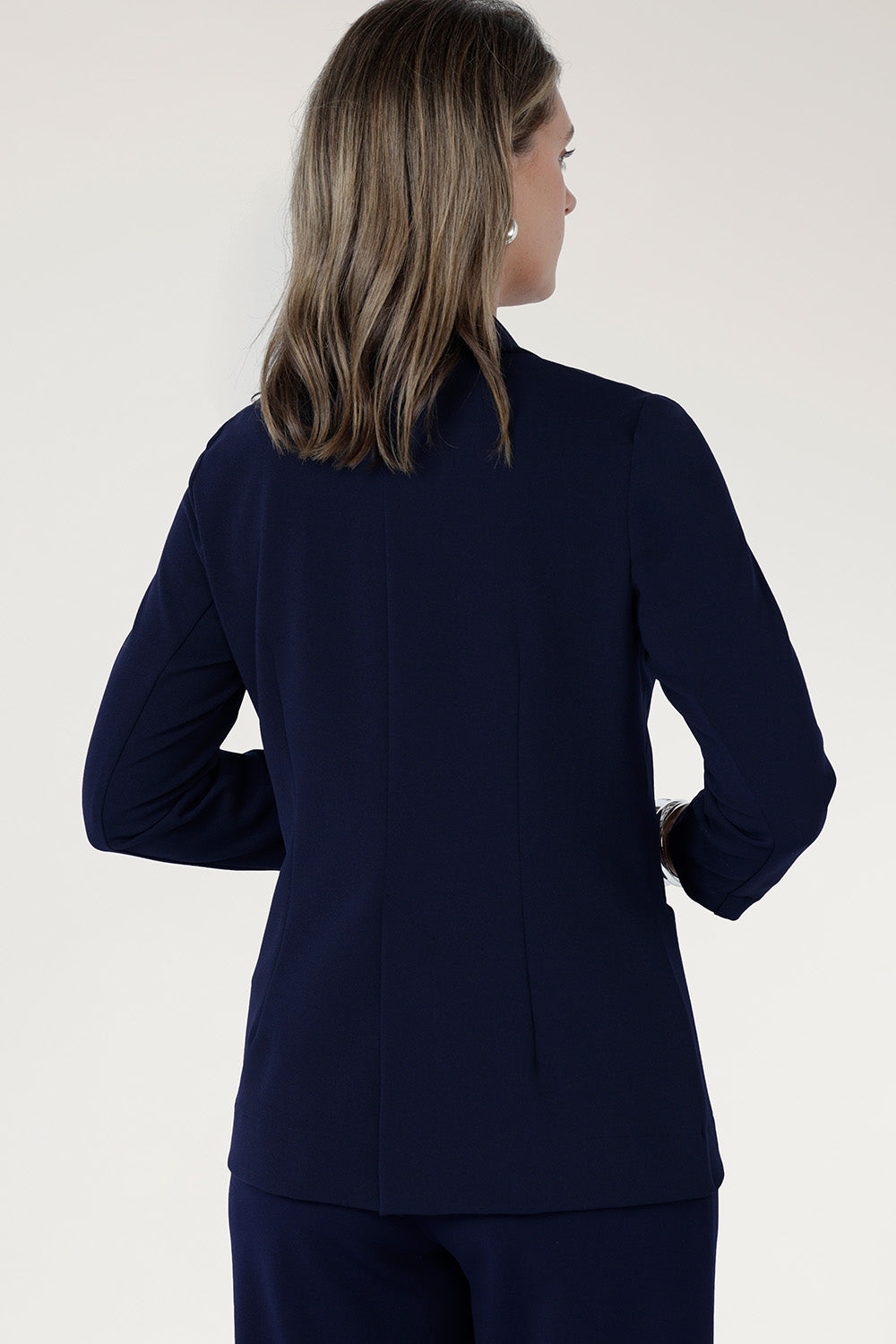  Perfect for work, Merit features a button front, full-length sleeves with foldable cuffs, and an extended shawl collar, offering versatile style and comfort.