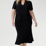 . Whether styled for the office, packed for a weekend escape, or dressed up for an evening out, the Michael Top delivers effortless sophistication with every wear. Plus size model wears her Micheal Shirt in Black 