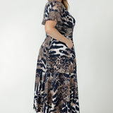 Australian-made Nicolle Dress featuring a fixed wrap bodice, elegant flutter sleeves and a flattering full skirt with ruffle hemline for effortless occasion dressing.