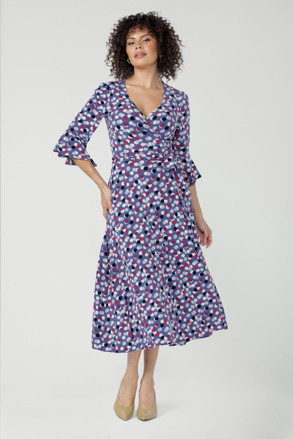 Featuring a soft wrap neckline, fluted 3/4 sleeves with gathered detail, and pockets, it’s designed with comfort, elegance and movement in mind.