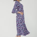Featuring a soft wrap neckline, fluted 3/4 sleeves with gathered detail, and pockets, it’s designed with comfort, elegance and movement in mind.