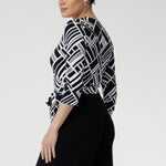 The contrast black jersey pants fall to a full length with a sleek straight leg and include functional side pockets, blending elegance with everyday ease. 